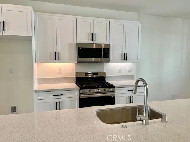 a kitchen with stainless steel appliances granite countertop a sink and a stove
