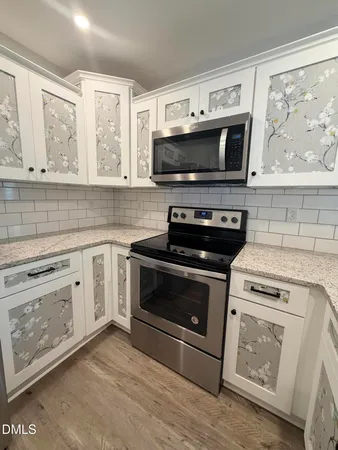 a kitchen with stainless steel appliances a stove microwave and sink