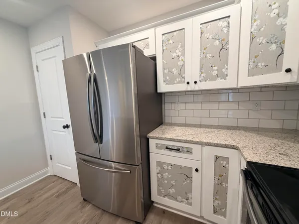 a kitchen with stainless steel appliances granite countertop a refrigerator and a stove