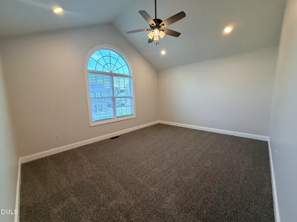 an empty room with windows and chandelier fan