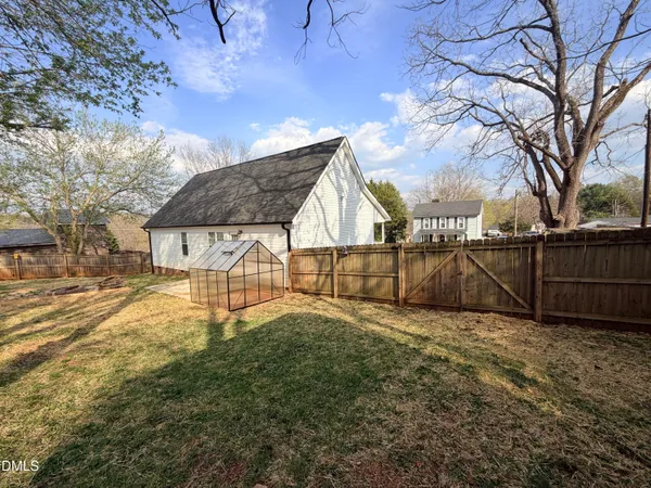 a view of backyard with wooden fence