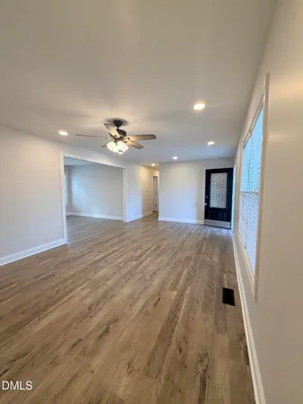 a view of empty room with wooden floor