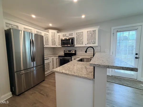 a kitchen with granite countertop a refrigerator and a sink