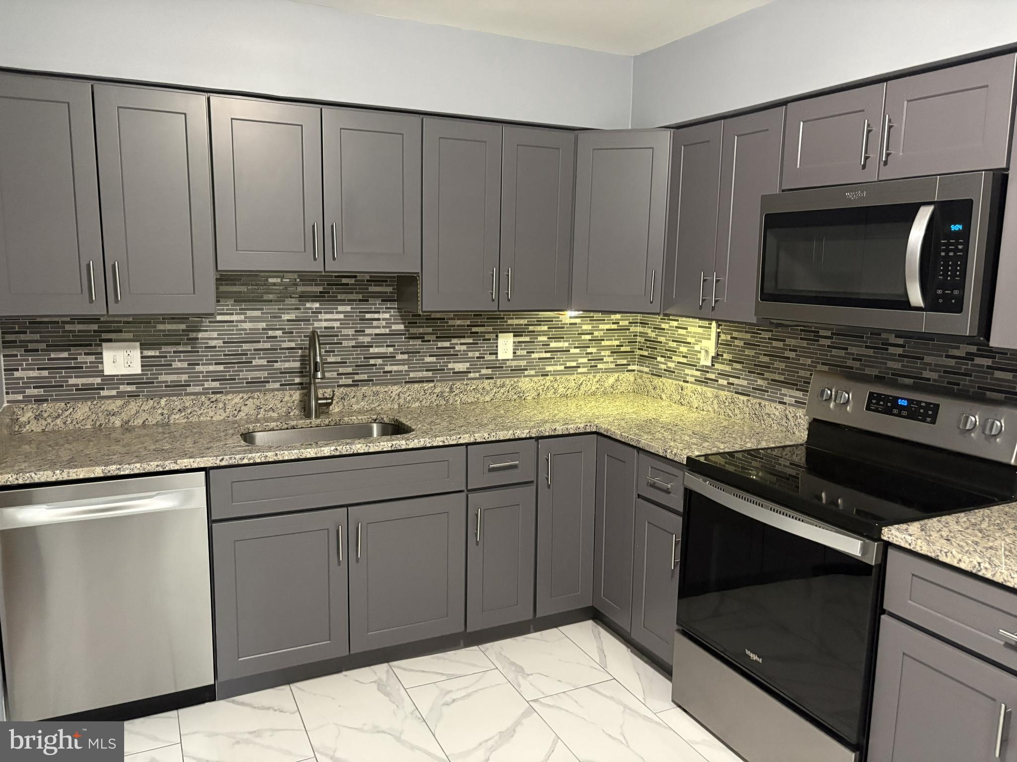 13242 Stravinsky Terrace Silver Spring, MD 20904 - Photo 2 of 11 a kitchen with stainless steel appliances granite countertop a stove a sink and a microwave