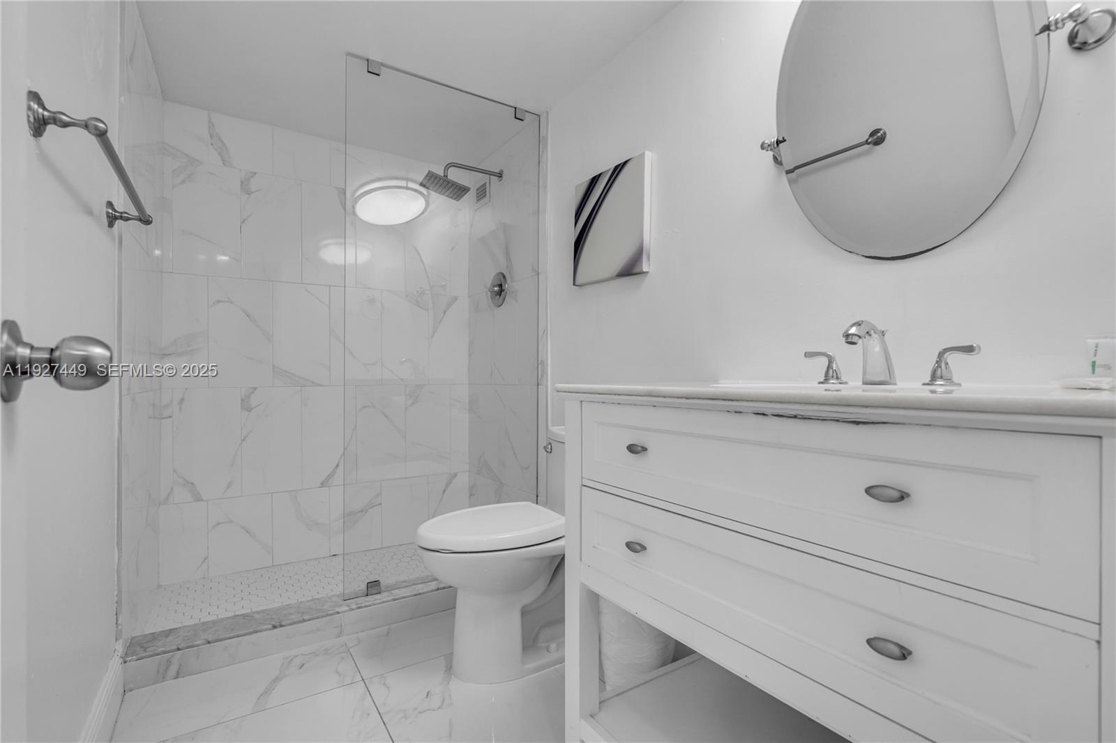 5101 Collins Avenue, Unit 12R Miami Beach, FL 33140 - Photo 4 of 13 a bathroom with a sink a toilet and a mirror