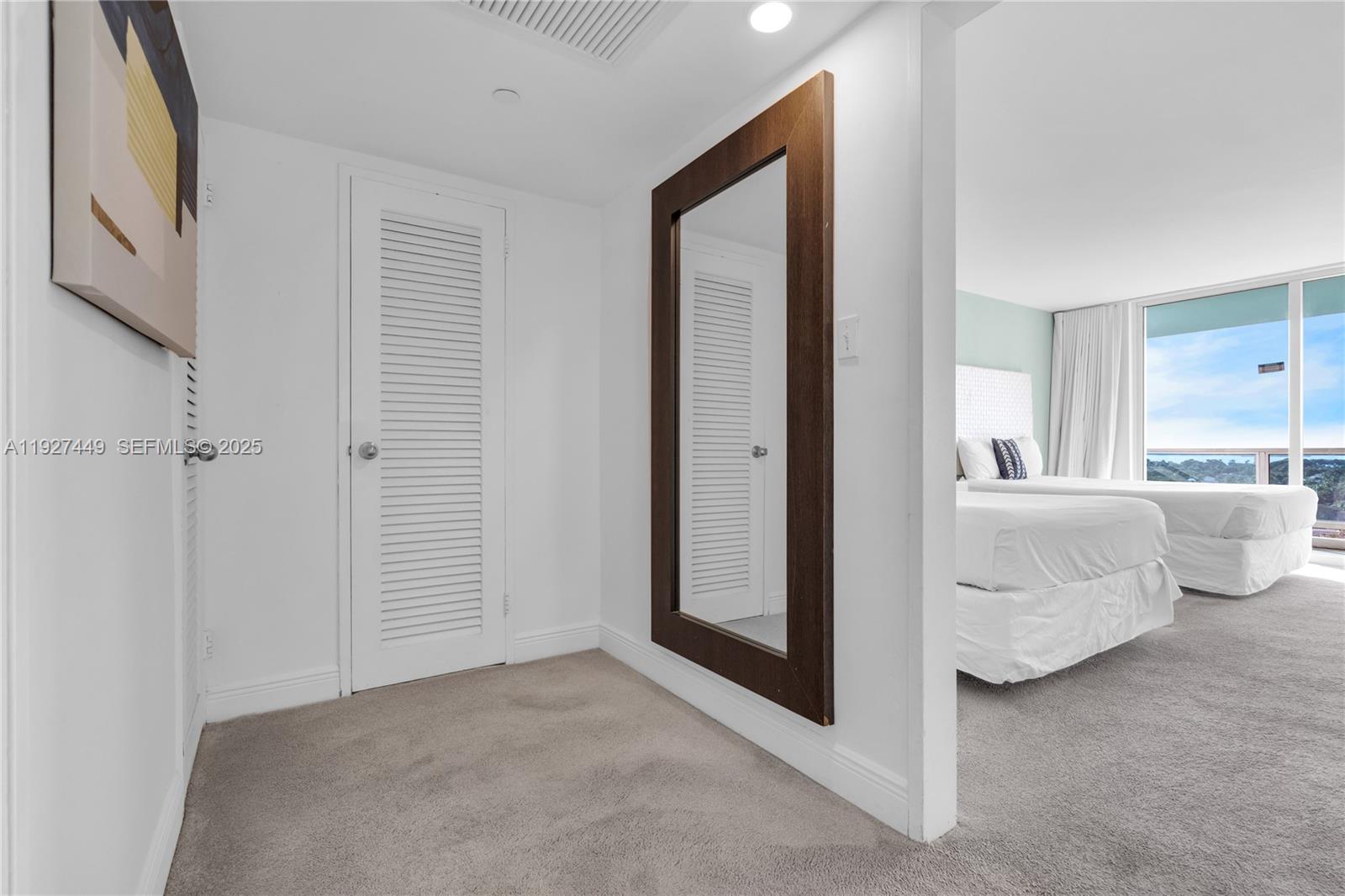5101 Collins Avenue, Unit 12R Miami Beach, FL 33140 - Photo 9 of 13 a view of a bedroom with closet and mirror