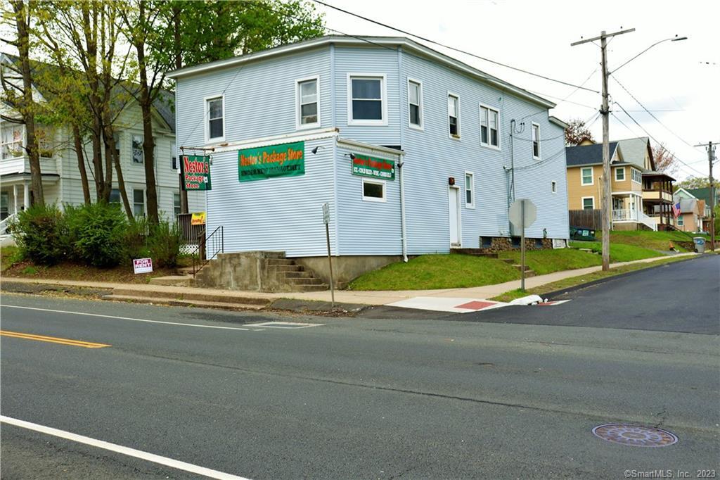 a view of a house with a small yard and large parking space