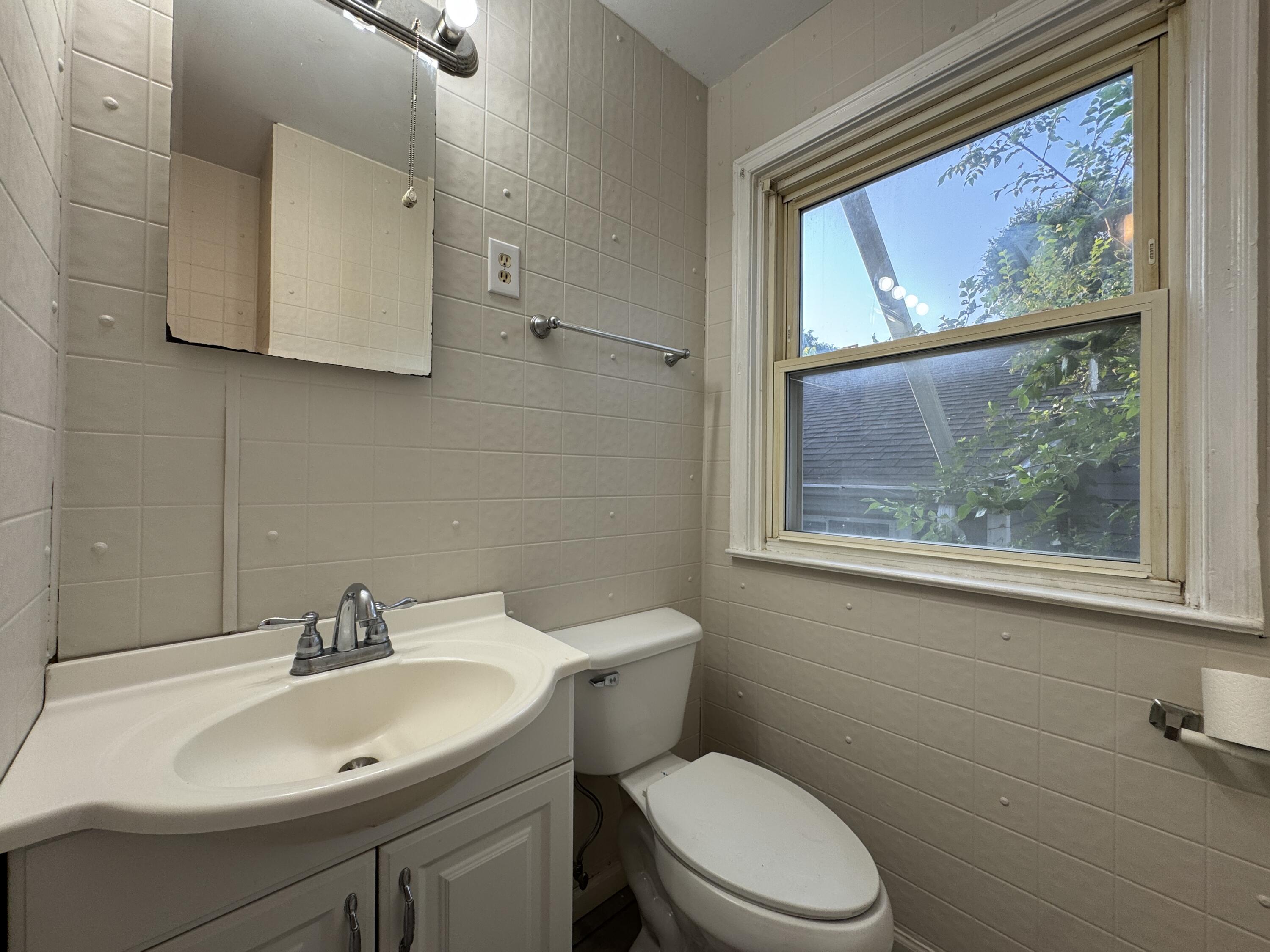403 Liberty Road Northeast Roanoke, VA 24012 - Photo 15 of 20 a bathroom with a toilet a sink and mirror