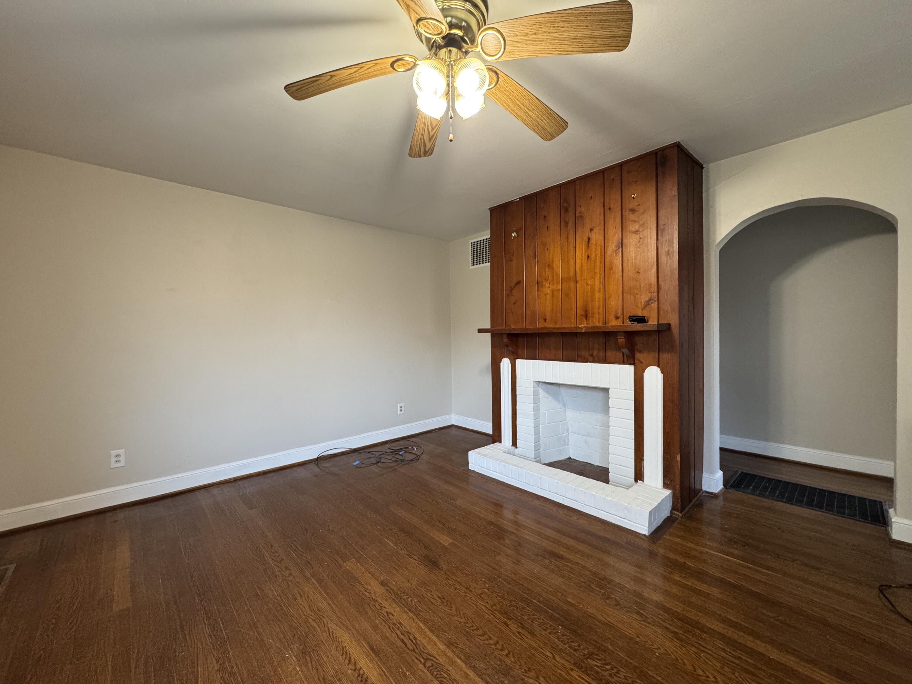 403 Liberty Road Northeast Roanoke, VA 24012 - Photo 4 of 20 an empty room with wooden floor fireplace and chandelier fan