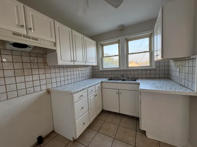 a kitchen with a sink window and cabinets