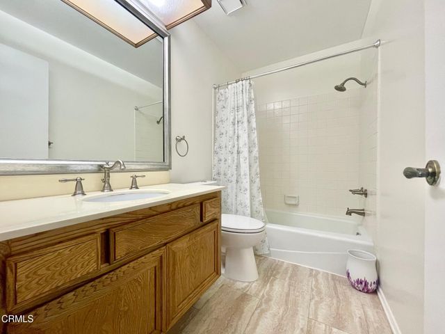 a bathroom with a sink a toilet a mirror a bathtub and shower