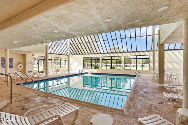 a view of a white house with a yard table and chairs
