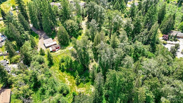 an aerial view of residential house with outdoor space and trees all around