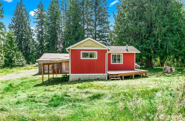 a front view of a house with a garden and trees