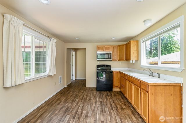 a kitchen with stainless steel appliances a stove top oven a sink and a refrigerator