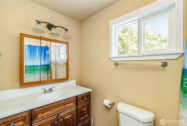 a bathroom with a sink a toilet and a window