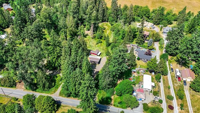 an aerial view of residential house with outdoor space and trees all around