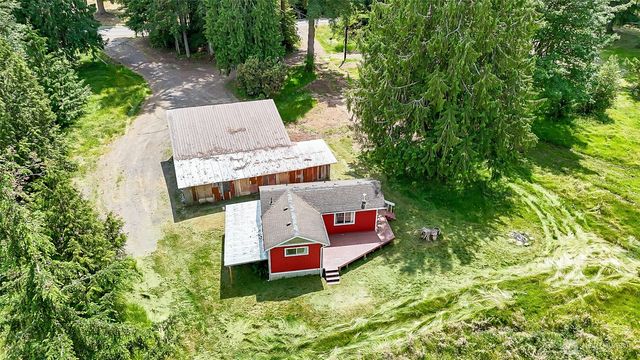 a aerial view of a house with swimming pool and red chairs