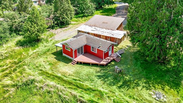 an aerial view of a house with swimming pool and red chairs