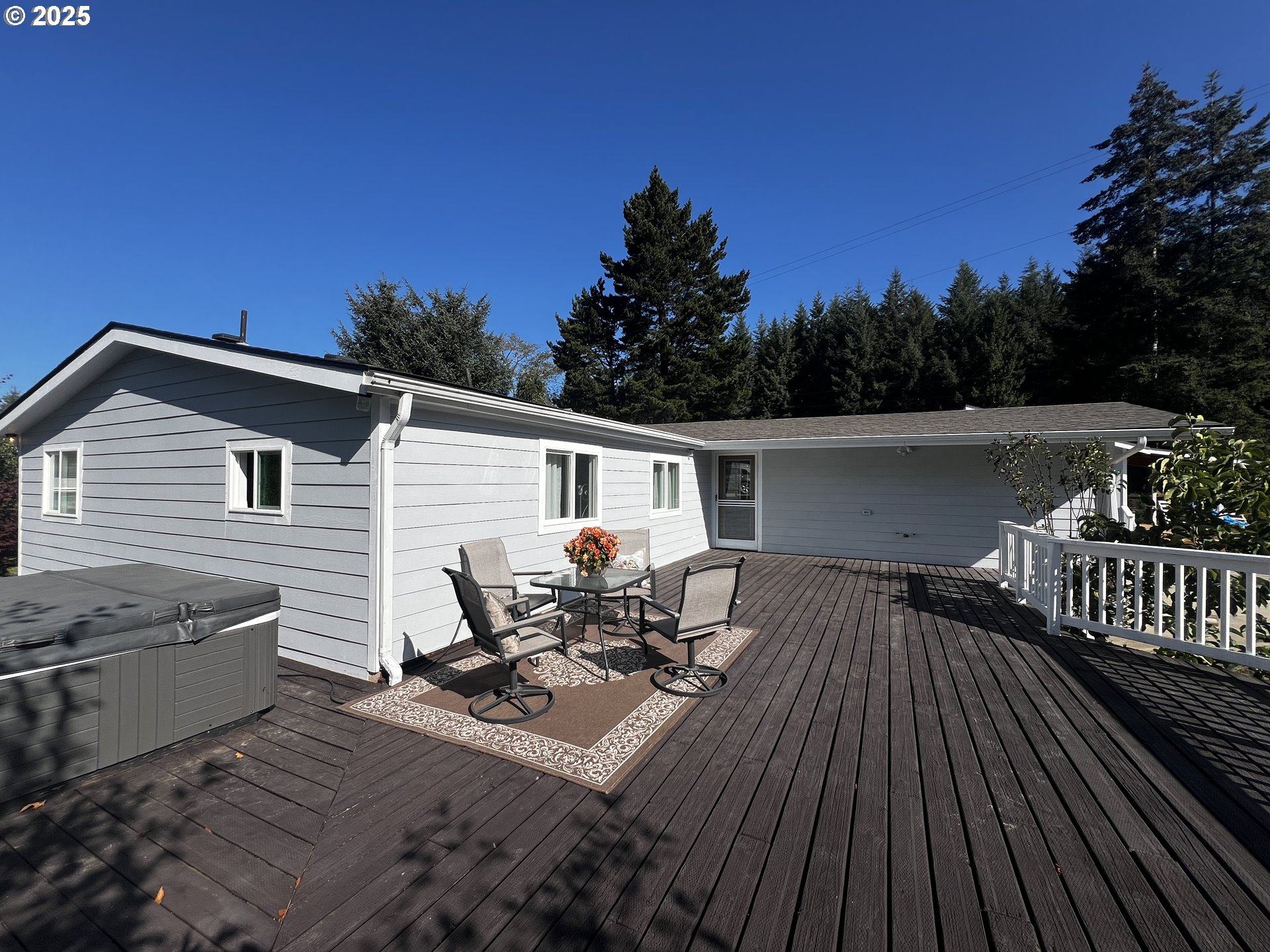 97040 Henderson Road Brookings, OR 97415 - Photo 3 of 36 a view of a roof deck with table and chairs with wooden floor and fence