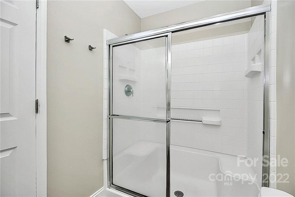 11630 Rabbit Ridge Road Charlotte, NC 28270 - Photo 21 of 32 a bathroom with a glass shower door