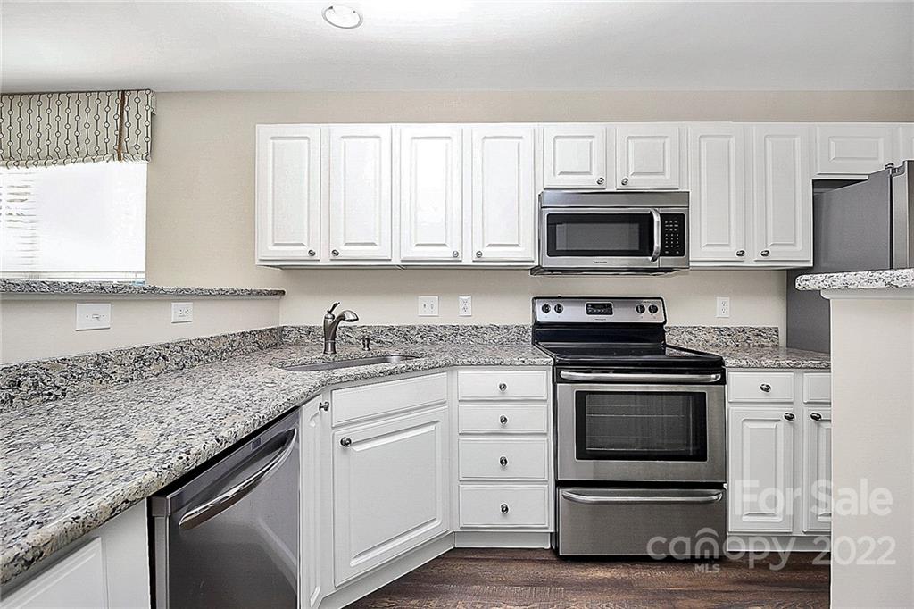 11630 Rabbit Ridge Road Charlotte, NC 28270 - Photo 5 of 32 a kitchen with granite countertop white cabinets and stainless steel appliances