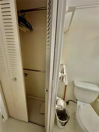 a white toilet sitting next to a shower