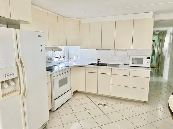 a kitchen with white cabinets and white appliances