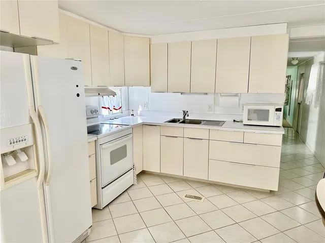 a kitchen with white cabinets and white appliances