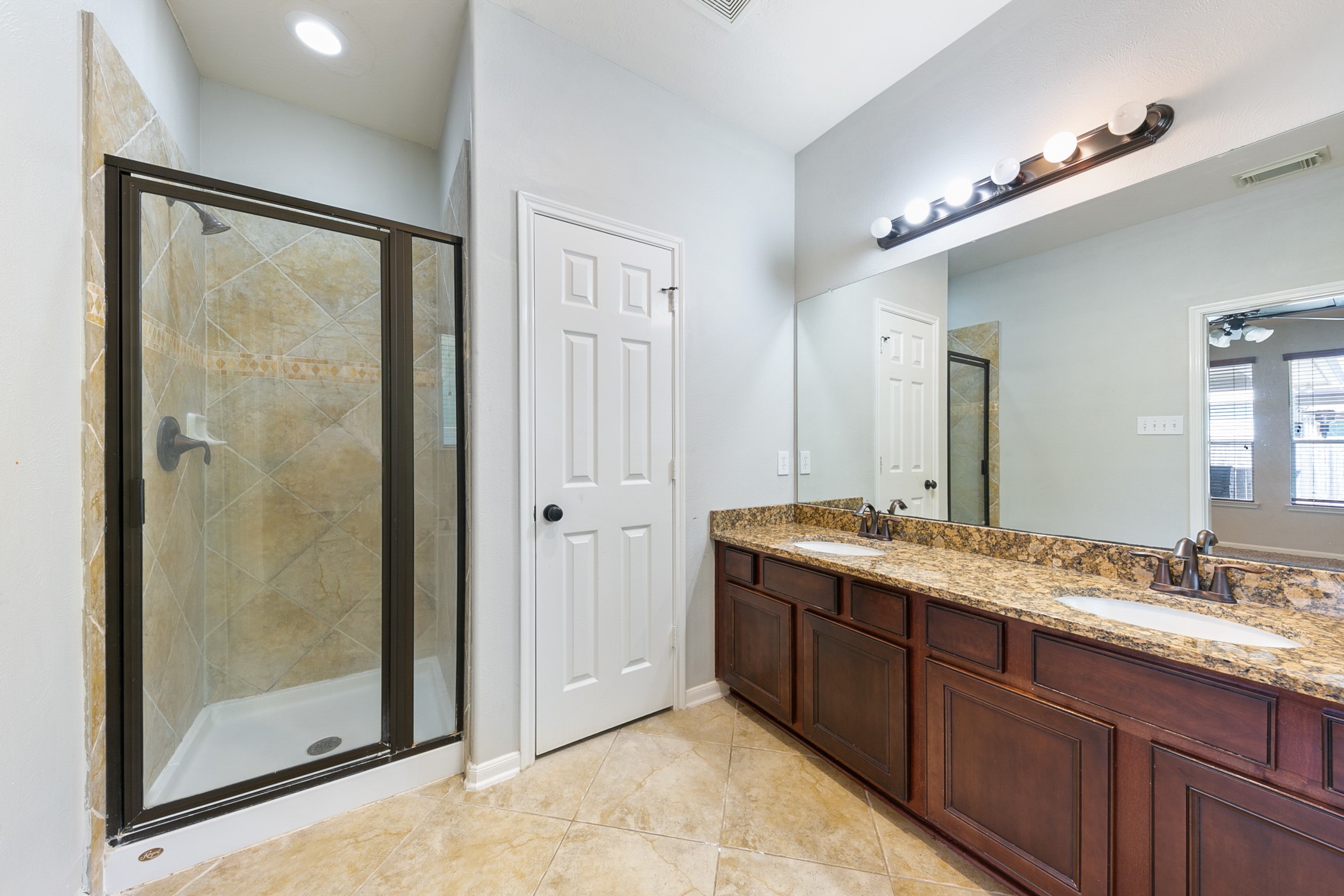 24527 Spring Harbor Drive Spring, TX 77373 - Photo 15 of 22 This bathroom features a spacious shower with glass doors, a dual-sink granite vanity, and ample lighting, creating a bright and functional space.