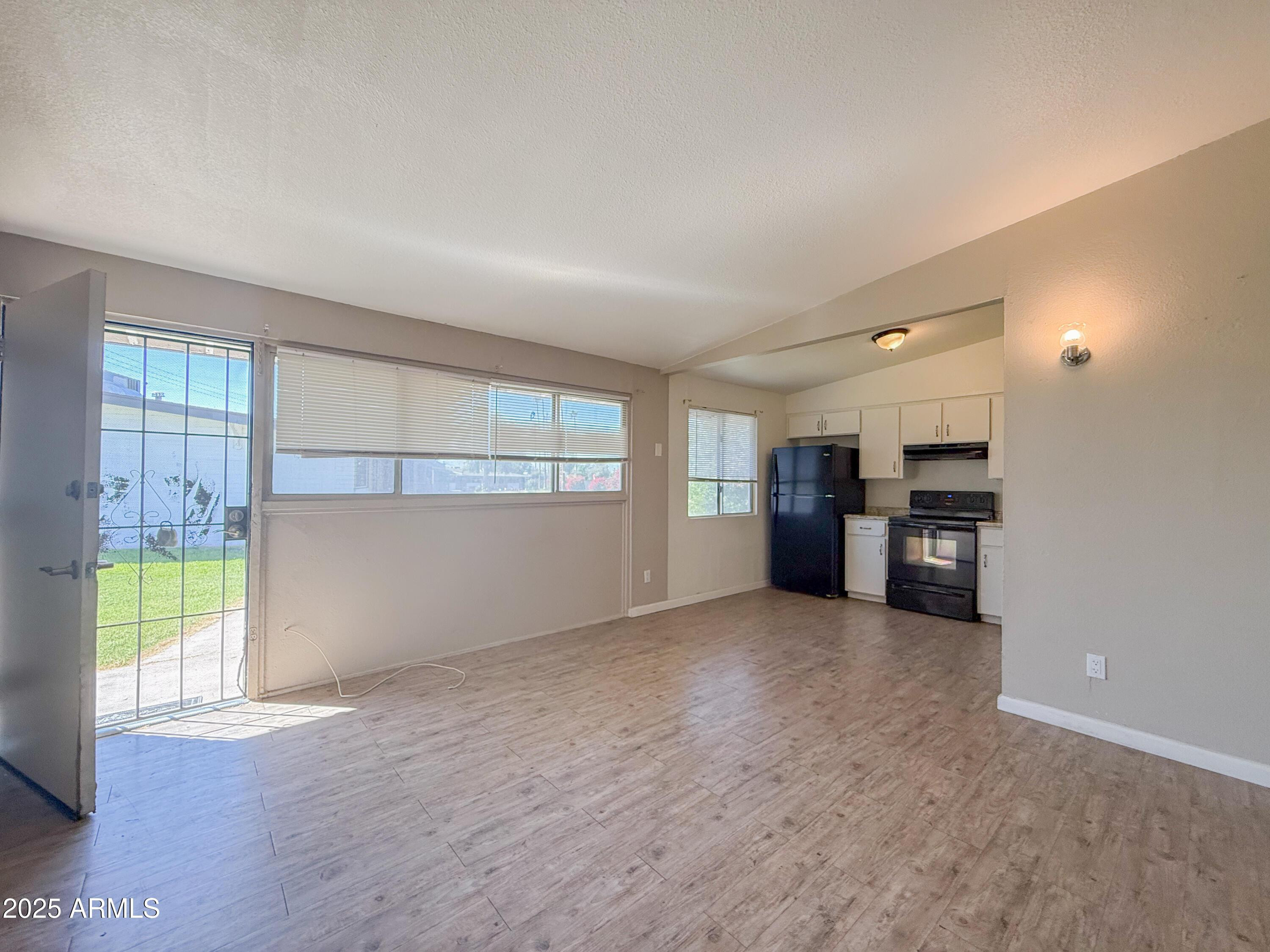 2123 West Devonshire Avenue, Unit 15 Phoenix, AZ 85015 - Photo 5 of 14 an empty room with a kitchen and a window