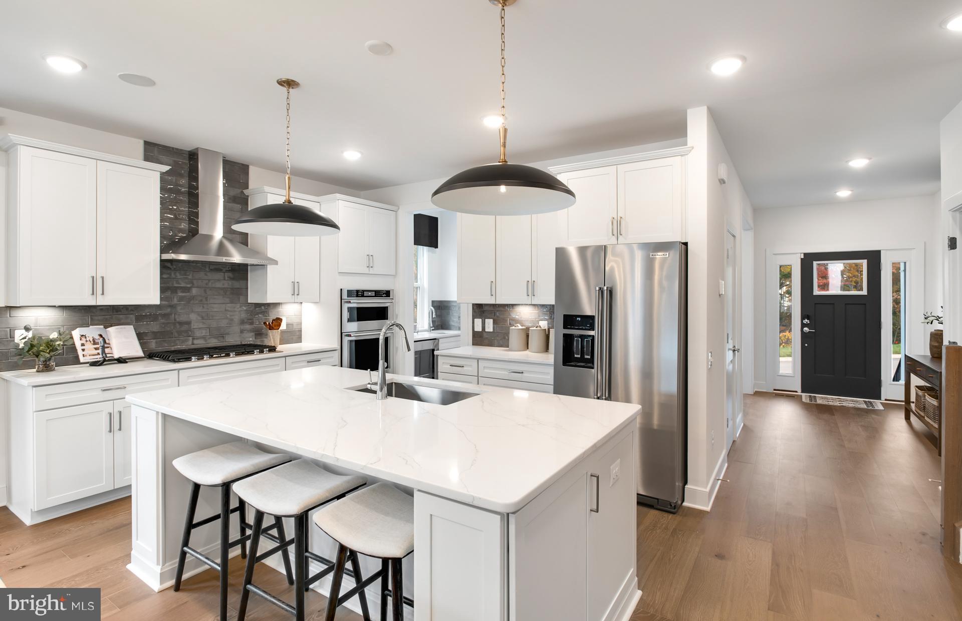 18260 Hobbes Rst Lane Leesburg, VA 20176 - Photo 3 of 63 a kitchen with stainless steel appliances a dining table chairs refrigerator and cabinets
