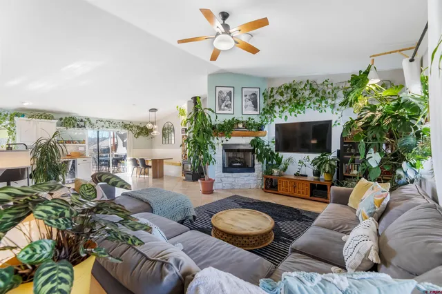 a living room with furniture a flat screen tv and a floor to ceiling window
