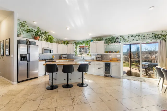 a kitchen with stainless steel appliances kitchen island granite countertop a refrigerator oven a sink and white cabinets