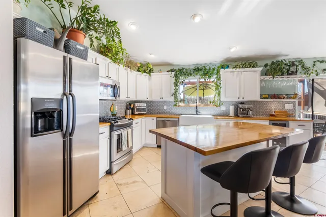 a kitchen with granite countertop white cabinets and stainless steel appliances
