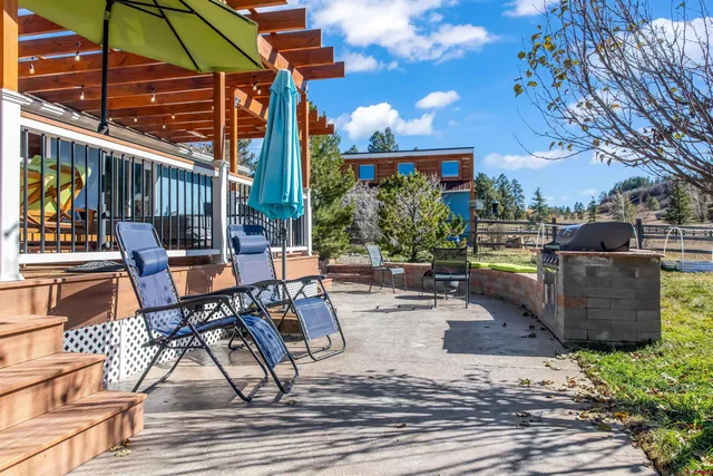 a view of a patio with table and chairs potted plants