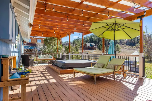 a view of a chairs and table on the wooden roof deck