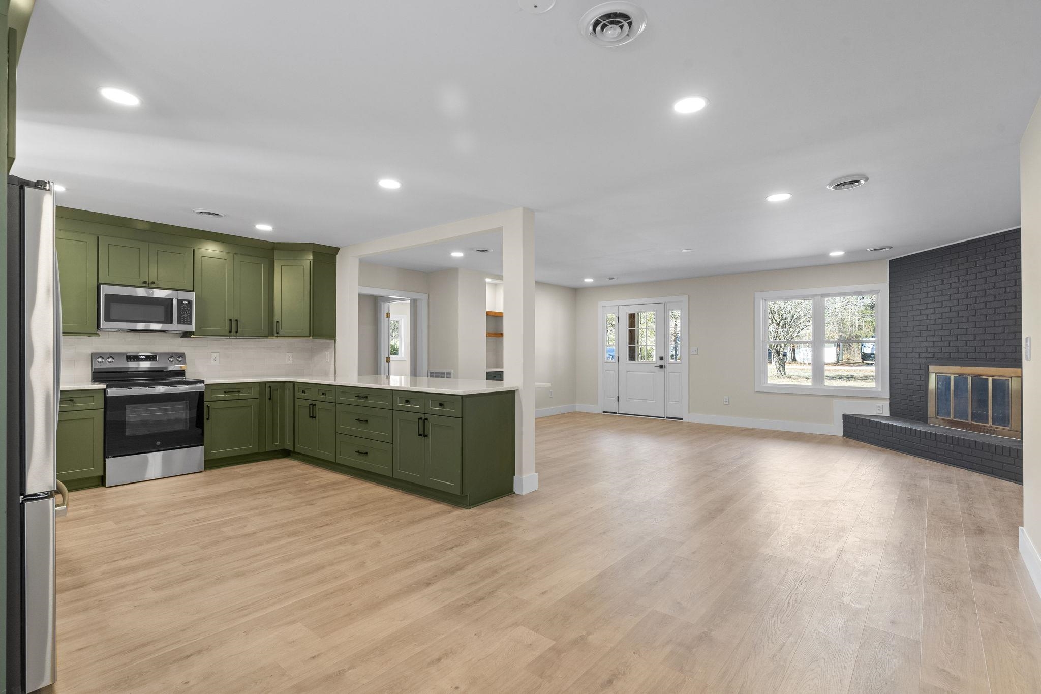 947 Fox Hollow Road Conway, SC 29526 - Photo 39 of 40 Kitchen featuring green cabinetry, appliances with stainless steel finishes, open floor plan, recessed lighting, and light wood-style floors