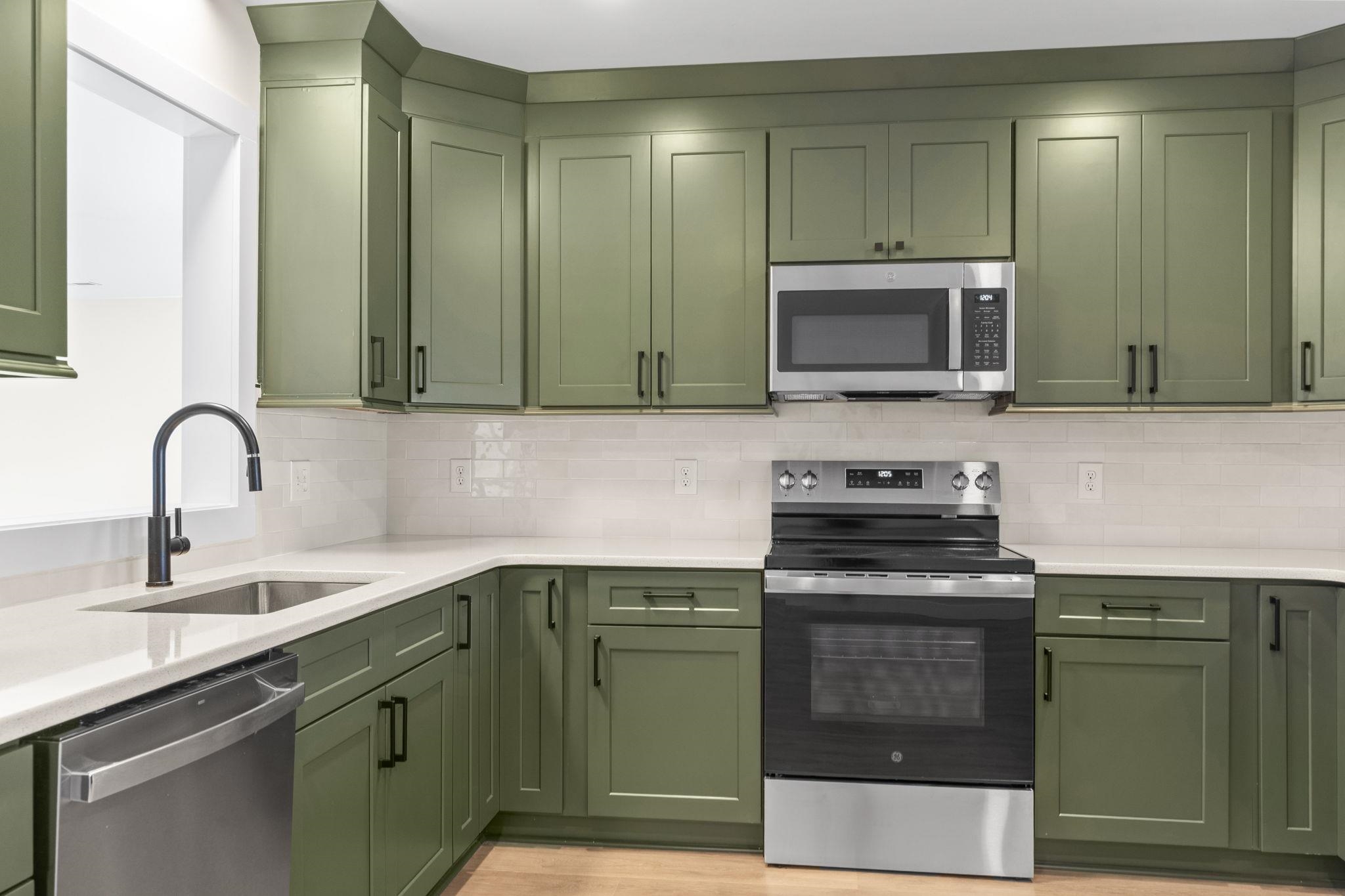 947 Fox Hollow Road Conway, SC 29526 - Photo 14 of 40 Kitchen with green cabinetry, stainless steel appliances, light stone countertops, and tasteful backsplash