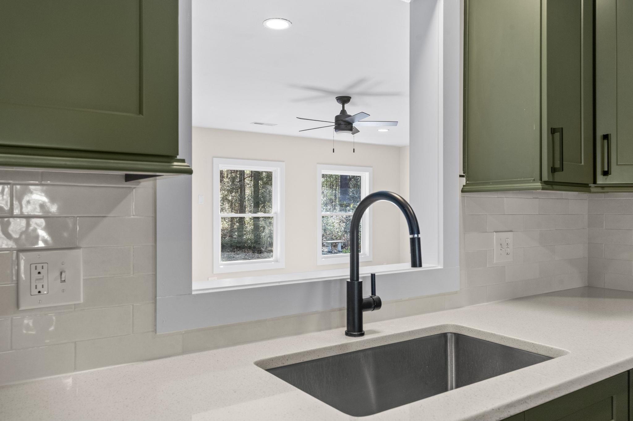 947 Fox Hollow Road Conway, SC 29526 - Photo 15 of 40 Kitchen with green cabinets, backsplash, light stone countertops, and a ceiling fan