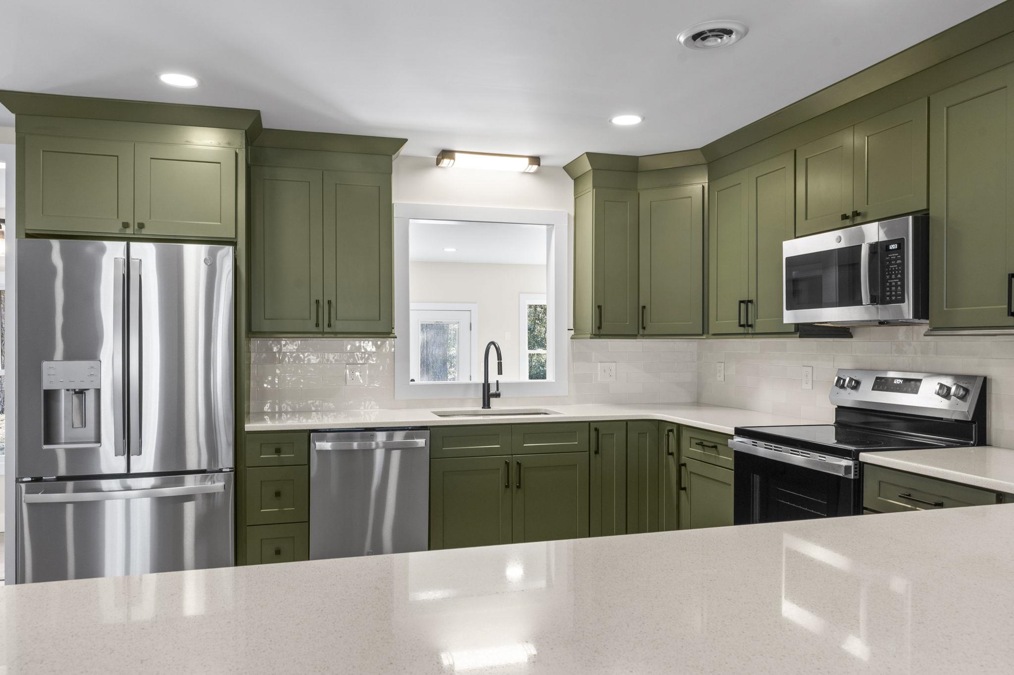 947 Fox Hollow Road Conway, SC 29526 - Photo 17 of 40 Kitchen featuring green cabinetry, stainless steel appliances, light stone counters, recessed lighting, and tasteful backsplash