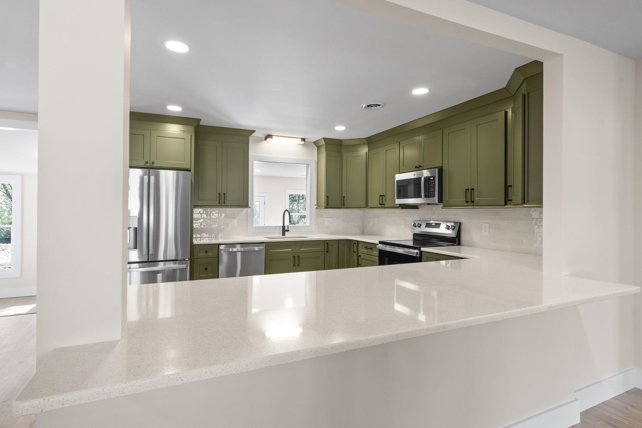 947 Fox Hollow Road Conway, SC 29526 - Photo 18 of 40 Kitchen with green cabinetry, stainless steel appliances, light stone counters, decorative backsplash, and recessed lighting