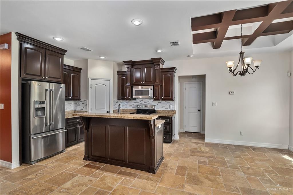 6707 South Rios Street Pharr, TX 78577 - Photo 5 of 17 a kitchen with stainless steel appliances granite countertop a refrigerator and a sink