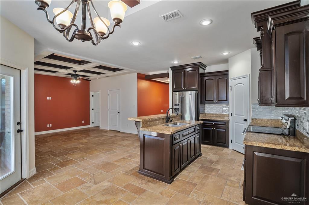 6707 South Rios Street Pharr, TX 78577 - Photo 6 of 17 a kitchen with stainless steel appliances granite countertop a stove a sink and a refrigerator