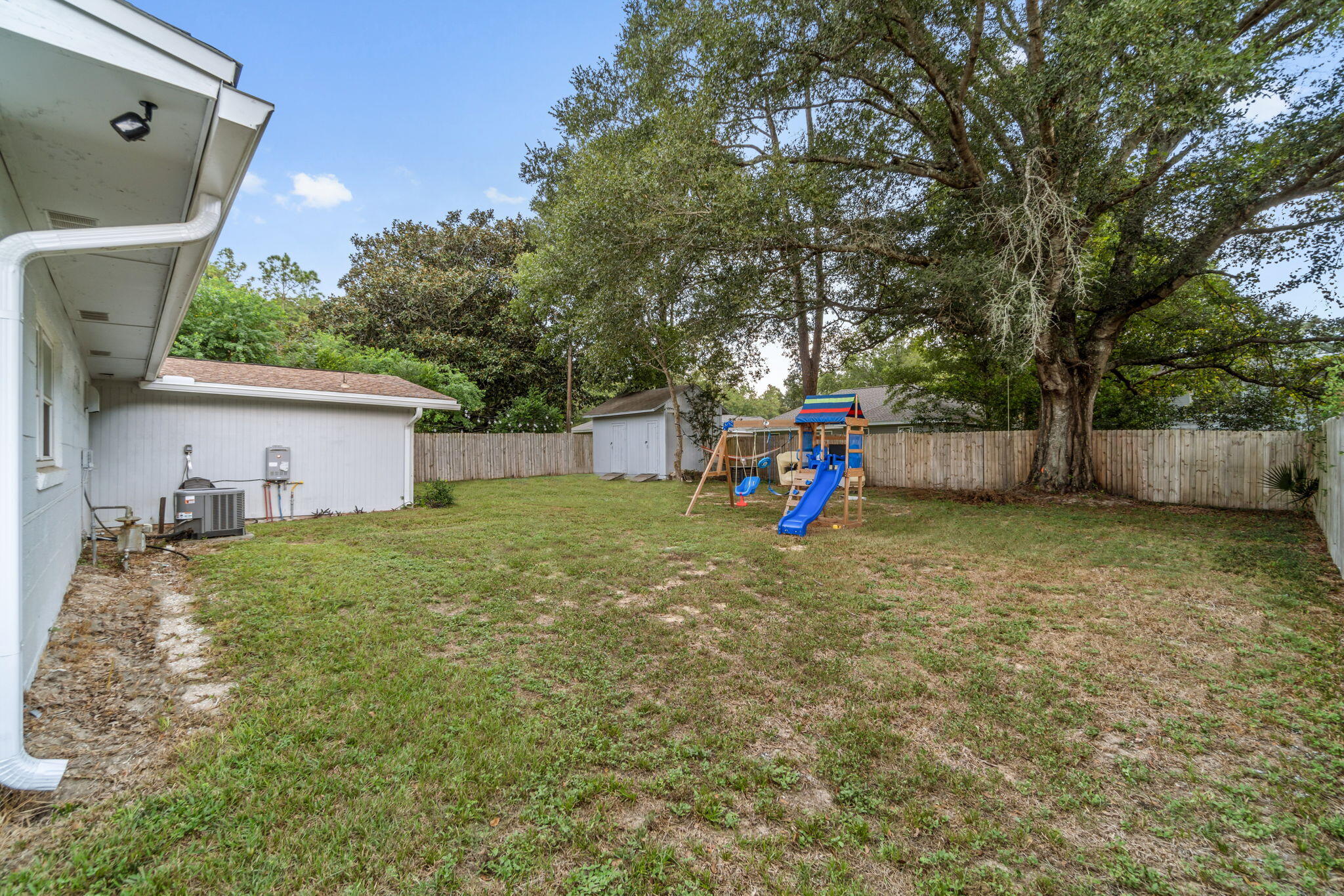 128 Sikes Drive Crestview, FL 32539 - Photo 22 of 24 a backyard of a house with childrens swings and slides