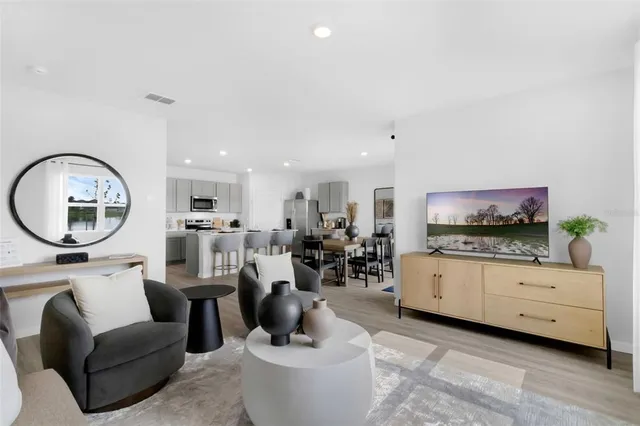 a living room with furniture a mirror and a flat screen tv