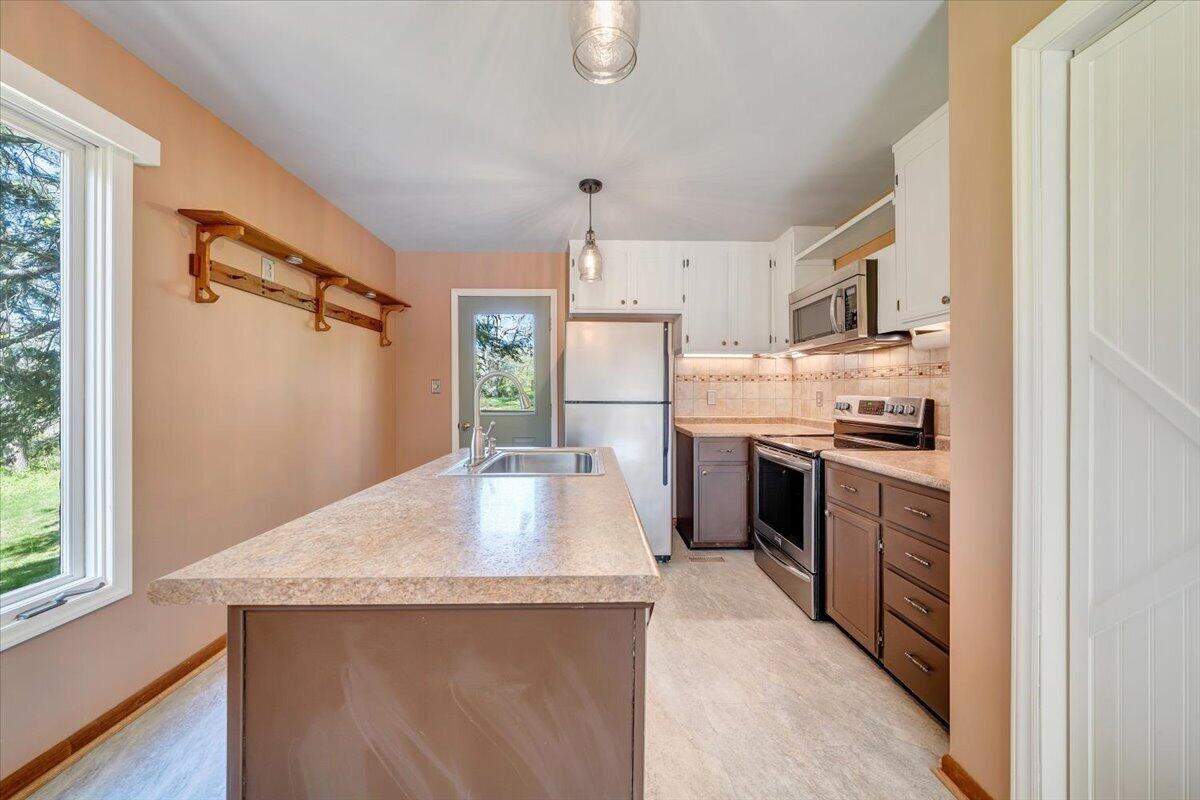 1465 Poff School Road Riner, VA 24149 - Photo 24 of 77 a kitchen with kitchen island a counter top space a sink stainless steel appliances and cabinets