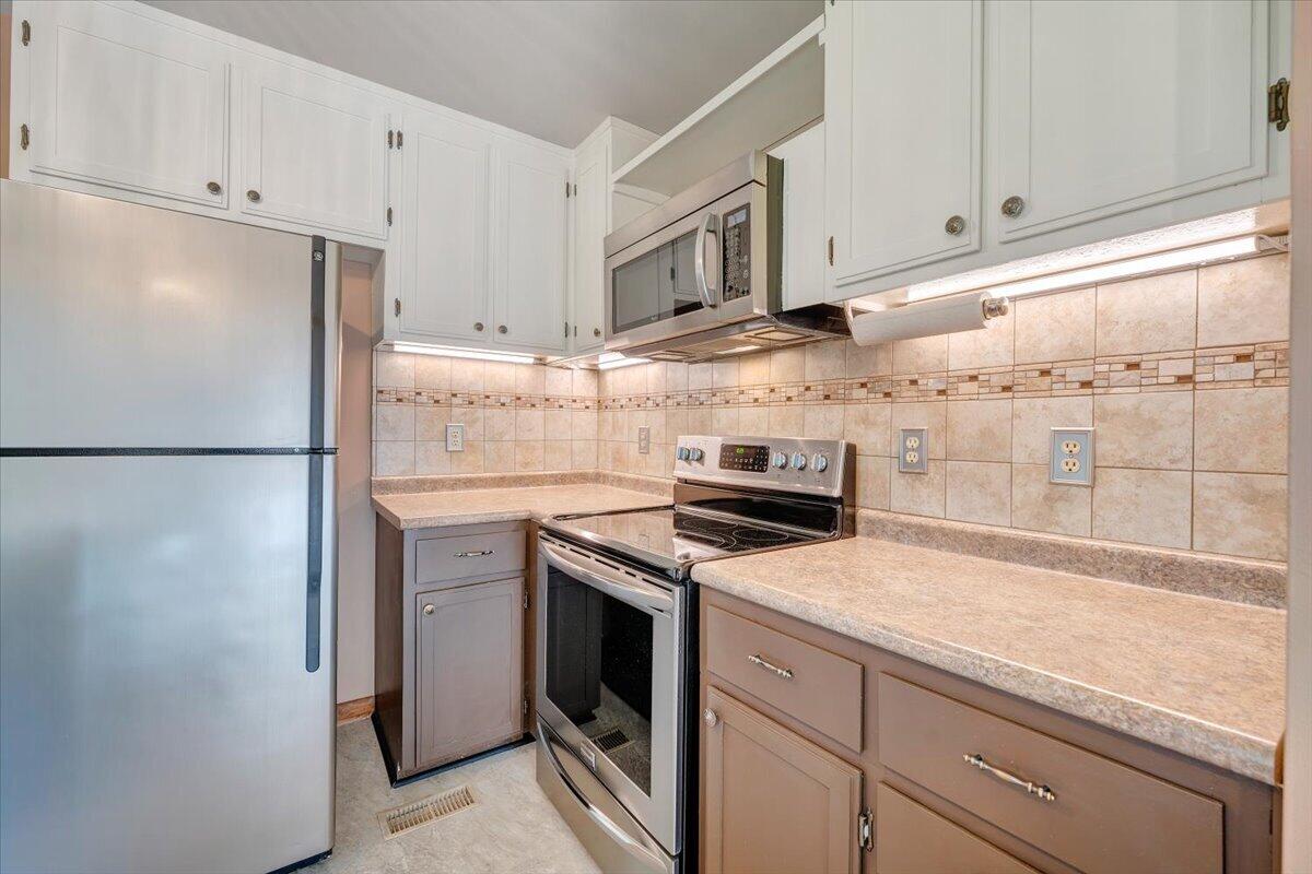 1465 Poff School Road Riner, VA 24149 - Photo 32 of 77 a kitchen with stainless steel appliances granite countertop a refrigerator a stove a sink and white cabinets