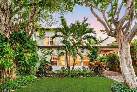 a front view of a house with a garden