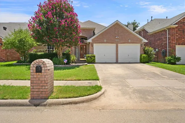 a front view of a house with a garden and plants